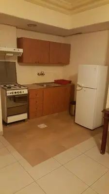 a kitchen with a white refrigerator and a stove at Al Khaleej Hotel Apartments in Amman