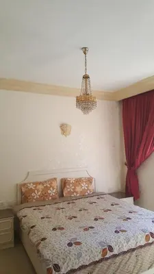 a bedroom with a bed and a chandelier at Al Khaleej Hotel Apartments in Amman