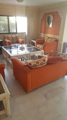 a living room with couches and a coffee table at Al Khaleej Hotel Apartments in Amman