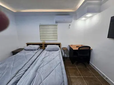 a bedroom with a large bed and a desk and a table at Cozy Studio 2 Central Amman, Near Rainbow Street in Amman
