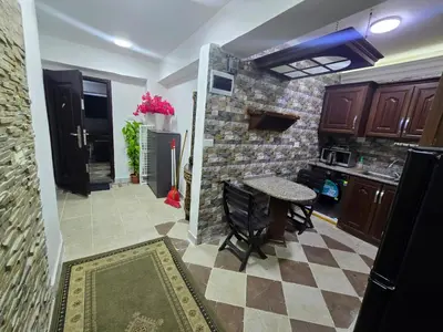 a kitchen with a table and a stone wall at Cozy Studio 2 Central Amman, Near Rainbow Street in Amman