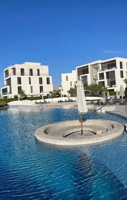 an umbrella in the water in front of buildings at Ayla apartment in Aqaba