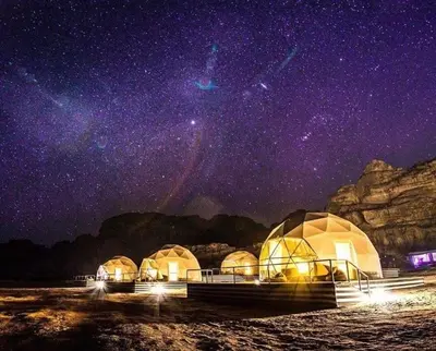 a group of domes in the water at night at Magic rum luxury camp in Wadi Rum