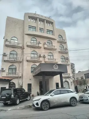 a building with cars parked in front of it at Power Stay Hotel in Amman
