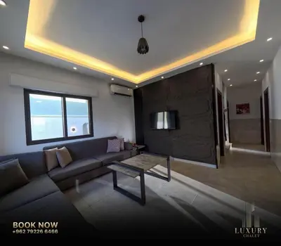 a living room with a couch and a table at Farm Luxury in Shūnat Nimrīn