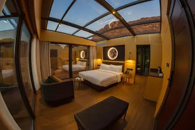 a bedroom with a bed and a chair in a room at Rum Reserve Resort-By Luxotel in Wadi Rum