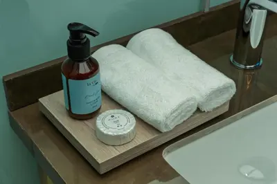 a bathroom sink with a bottle of soap and towels at Rum Reserve Resort-By Luxotel in Wadi Rum