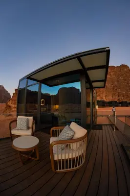 a deck with couches and a table and chairs on a deck at Rum Reserve Resort-By Luxotel in Wadi Rum