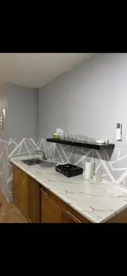 a kitchen with a white counter top and a counter top at Rabieh Rose in Amman