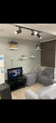 a living room with a couch and a tv at Rabieh Rose in Amman