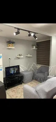 a living room with a couch and a tv at Rabieh Rose in Amman