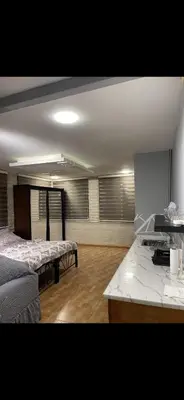 a room with two beds and a table in it at Rabieh Rose in Amman