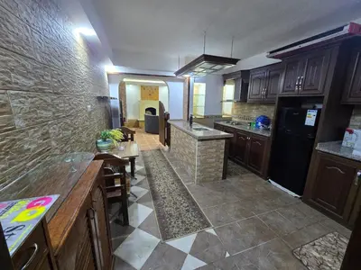 a kitchen with wooden cabinets and a stone wall at Studio 3 Cozy Amman Central Near Rainbow Street & First Circle in Amman
