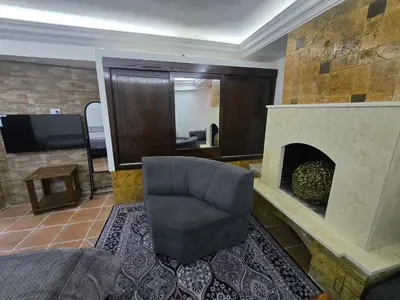 a living room with a chair and a fireplace at Studio 3 Cozy Amman Central Near Rainbow Street & First Circle in Amman