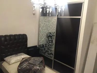a bedroom with a bed and a black cabinet at شقة مفروشة للإيجار بالرابية بالقرب من السفارة الصينية in Amman