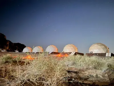a group of domes in a field at night at Ahmad Wadi Rum Camp in Wadi Rum