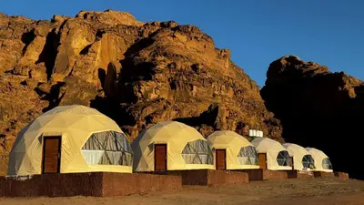a row of domes in front of a mountain at Ahmad Wadi Rum Camp in Wadi Rum