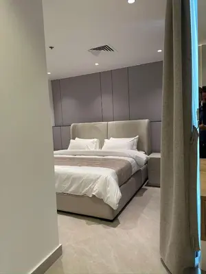 a bedroom with a large bed with white sheets at Damac Amman Modern Luxury Apartment in Amman