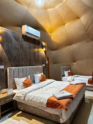 two beds in a room with a ceiling at Jorye Rum luxure cam in Wadi Rum