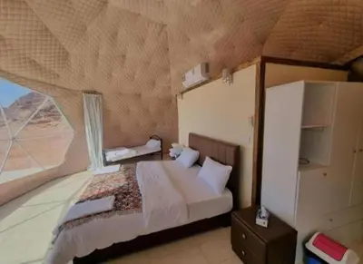 a bedroom with a bed and a large window at Jorye Rum luxure cam in Wadi Rum