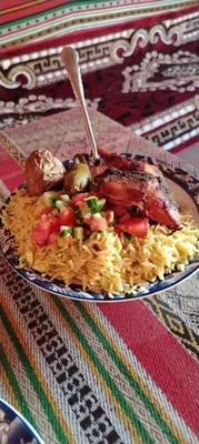 a plate of food with meat and vegetables on a table at Nature rum camp in Wadi Rum