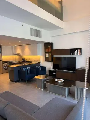 a large living room with a couch and a kitchen at DAMAC AMMAN LUXURY APARTMENTs داماك عمان شقق فاخرة in Amman