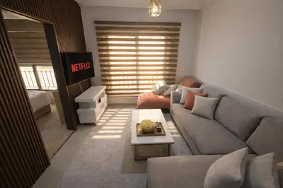 a living room with a couch and a table at Cozy Studio Gardens St Neighborhood in Amman