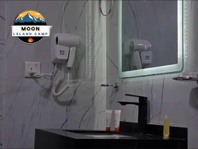 a bathroom with a sink and a mirror and a hair dryer at MOON ISLAND lUXURY CAMP in Wadi Rum