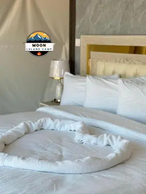 a white bed with a moon sign on top of it at MOON ISLAND lUXURY CAMP in Wadi Rum