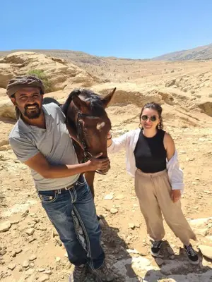 a man and a woman with a horse in the desert at Bedouin Family Camp in Al Ḩayy