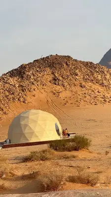 a tent sitting in the middle of a desert at Wadi Ram camp in Disah