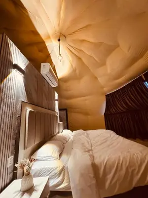 a bedroom with a large bed with a ceiling at Wadi Ram camp in Disah
