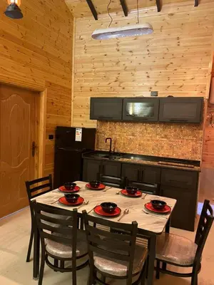 a kitchen with a table with chairs and a sink at شاليه غصن in Ajloun