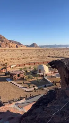 a view of a desert with a building in the distance at Amjad Rum Camp in Disah