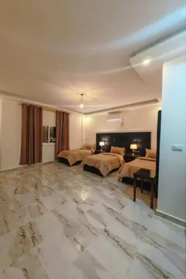 a large bedroom with two beds and a marble floor at I cloud Petra hostel in Wadi Musa