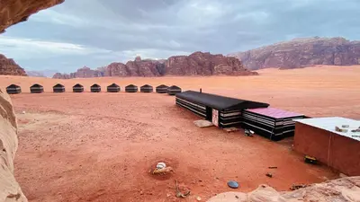 a group of buildings in the desert with mountains at wadi Rum Desert Legends in Wadi Rum