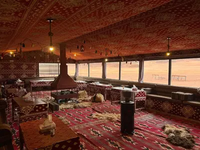 a large room with tables and chairs on a rug at wadi Rum Desert Legends in Wadi Rum