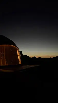 a tent sitting in the desert at sunset at Tariq Camp Wadi Rum in Wadi Rum
