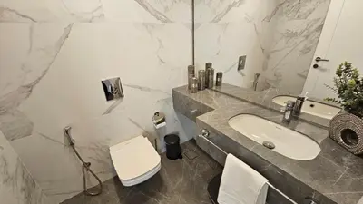 a bathroom with a sink and a toilet and a mirror at Luxury 2-BR Apartment Abdali Boulevard Family in Al Jafr