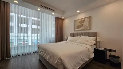 a bedroom with a large bed and a large window at Luxury 2-BR Apartment Abdali Boulevard Family in Al Jafr
