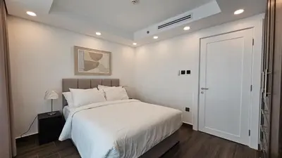 a bedroom with a white bed and a white door at Luxury 2-BR Apartment Abdali Boulevard Family in Al Jafr