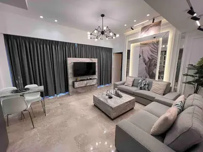 a large living room with a couch and a tv at Luxury one bedroom apartment at Damac towers in Amman
