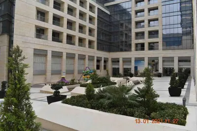 a building with a lot of plants in front of it at Luxury one bedroom apartment at Damac towers in Amman