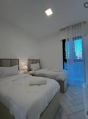 a bedroom with two beds and a window at Seaside Luxury Apartment with Terrace and BBQ in Aqaba