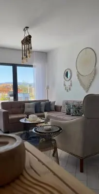 a living room with a couch and tables at Seaside Luxury Apartment with Terrace and BBQ in Aqaba
