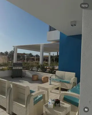 a rendering of a patio with chairs and a table at Seaside Luxury Apartment with Terrace and BBQ in Aqaba