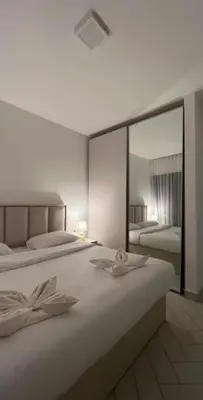a bedroom with two beds and a large mirror at Seaside Luxury Apartment with Terrace and BBQ in Aqaba