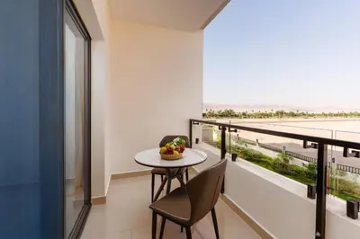 a balcony with a table and chairs and a view of the ocean at Golden Pillar Hotel in Aqaba
