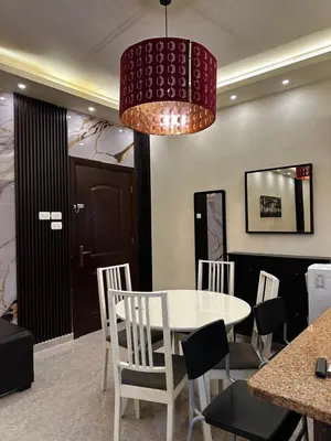 a dining room with a white table and chairs at شقة بالرابية in Amman