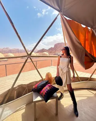 a woman is standing inside of a boat at BUBBLES CAMp in Wadi Rum